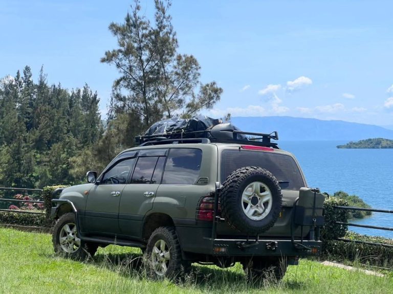Toyota Land Cruiser Prado TXL 4x4 car rental from Kigali Car Rent parked on a scenic mountain road near Volcanoes National Park in Rwanda